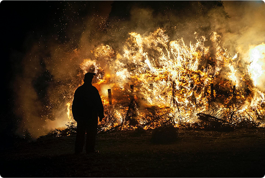 Firefighter observing a burning house