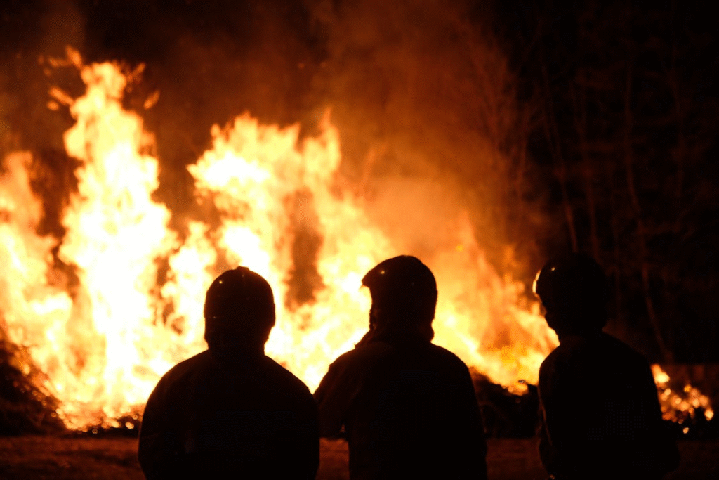 Silhouetted firefighters battle an intense blaze
