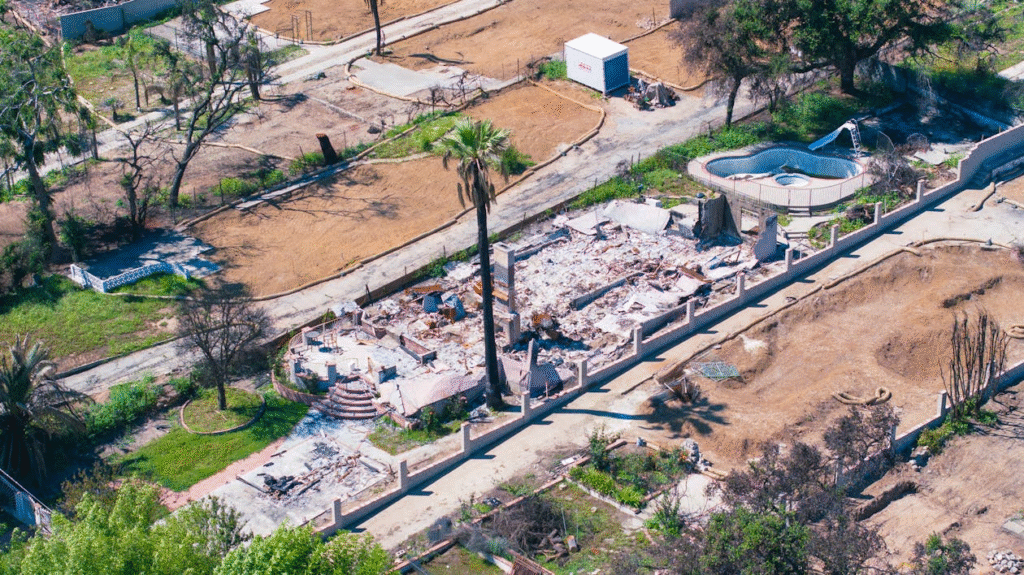 Aerial view of a wildfire-damaged home and property

